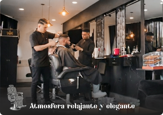 Vista interior de la barbería con sillones de cuero y barberos trabajando, mostrando una atmósfera relajante, elegante y profesional.